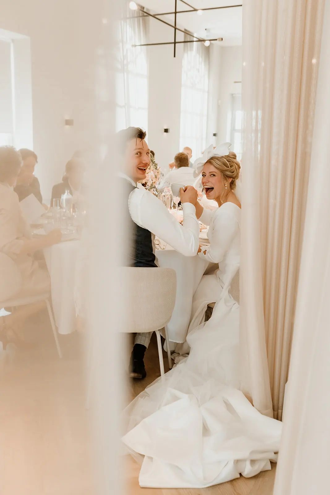 Lachend bruidspaar aan tafel — neem contact op met Marilyn Fotografie